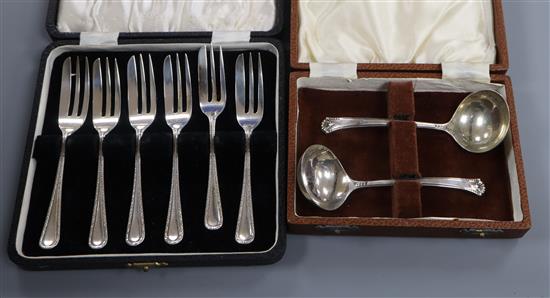 A cased set of six 1940s silver pastry forks and a cased pair of silver cream ladles.